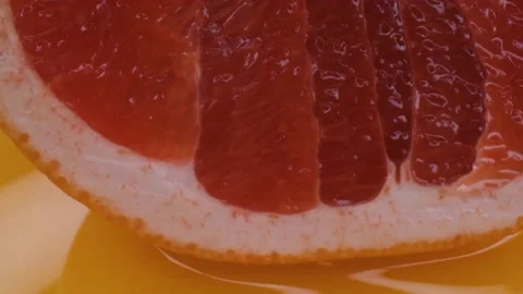 Grapefruit macro shooting,isolated half grapefruit on yellow background rotates Stock Footage 130996439