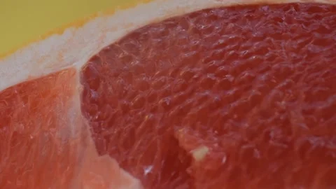 Grapefruit macro shooting,isolated half grapefruit on yellow background rotates Stock Footage 130997084