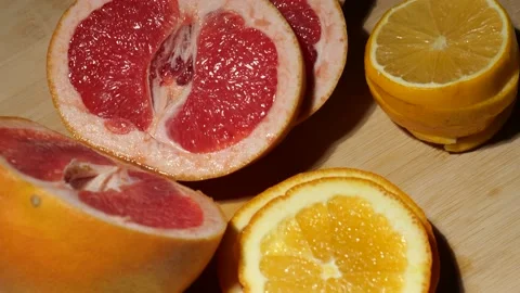 Grapefruit, oranges and lemon sliced on a bamboo board Stock Footage 146147154