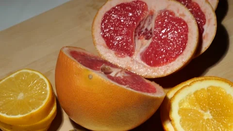 Grapefruit, oranges, lemon and pineapple sliced on a bamboo board Stock Footage 146147112