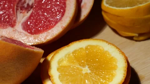 Grapefruit, oranges, lemon and pineapple sliced on a bamboo board Stock Footage 146147339