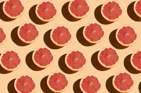 Grapefruit pattern on a beige background. Orange juicy grapefruit cut with Stock Photos