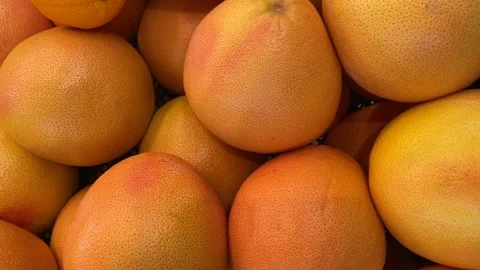 Grapefruit pile with orange and pink hues, showcasing texture and color, su.. Stock Footage 344419537