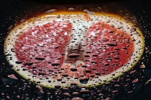 Grapefruit pulp with drops of moisture on a black mirror Stock Photos