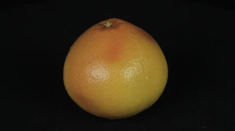 Grapefruit rotates on a black background Stock Footage 35740706