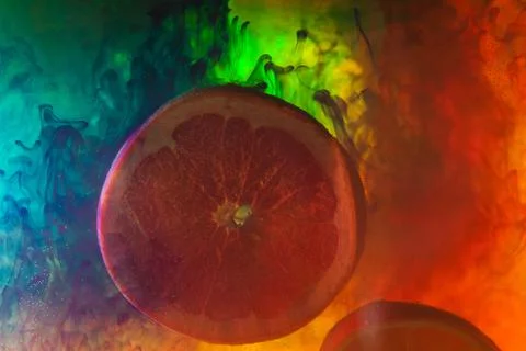 Grapefruit slice on an abstract background with colorful smoke Illustrazione stock