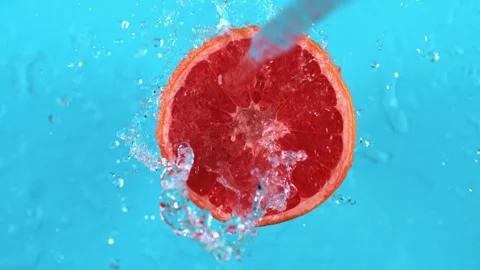 Grapefruit slice falling under stream of refreshing clean water Stock Footage 327573552