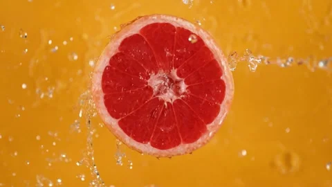 Grapefruit slice hit by water stream slow motion action Stock Footage 327573378