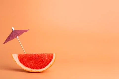 Grapefruit slice on a orange background. Summer, vacation and travel minimal  Stock Photos
