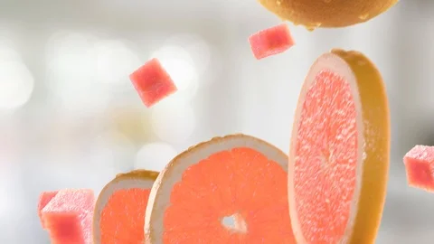 Grapefruit with Slices Falling on Kitchen Background Stock Footage 107944370