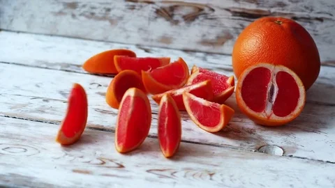 Grapefruit slices falling on a wooden table. Slow motion shot Video stock 71450703