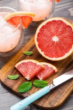 Grapefruit with slices on a table. Stock Photos