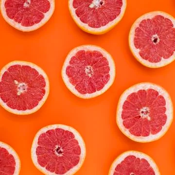 Grapefruit split in half and placed on orange background Stock Photos
