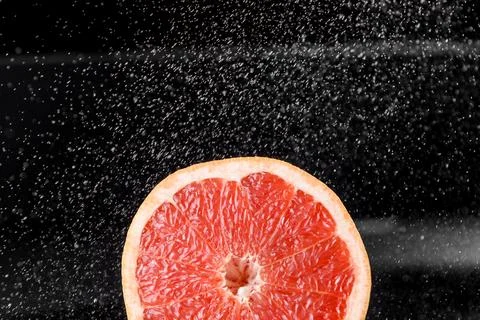 Grapefruit with water drops on black background. Citrus fruit. Healthy freshn Stock Photos