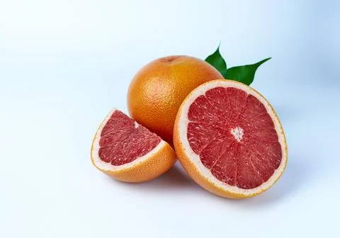Grapefruit whole, cut in half and a quarter on a white background close-up. Stock Photos