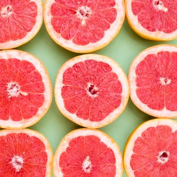 Grapefruits split in half close-up on green background Stock Photos
