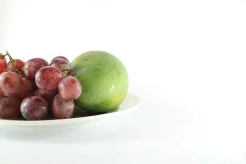 Grapes and mango in the plate Stock Photos