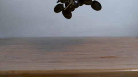 Grapes being dropped onto a cutting board in slow motion Stock Footage 100008433