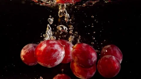 A grapes falling into the water with air bubbles. On a black background. Video stock 147986500