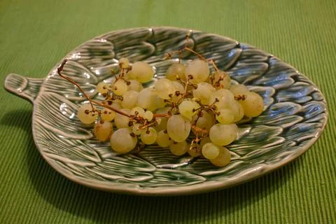 Grapes on a grape leaf-shaped plate Stock Photos