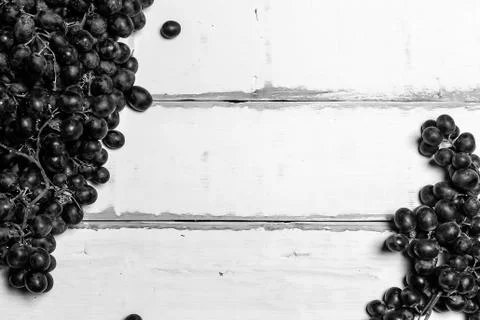 Grapes lying on a wooden table Stock Photos