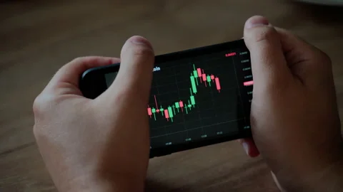 Graph of crypto currency online. Man holding smartphone and looking on Quotes Stock Footage 157284756