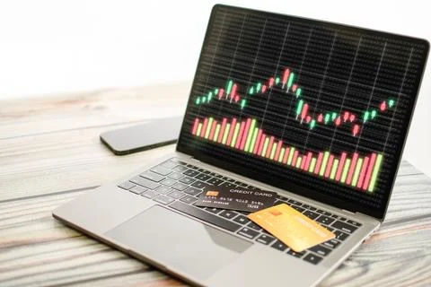 The graph displayed on a laptop screen and a credit card placed on the keyb.. Stock Photos