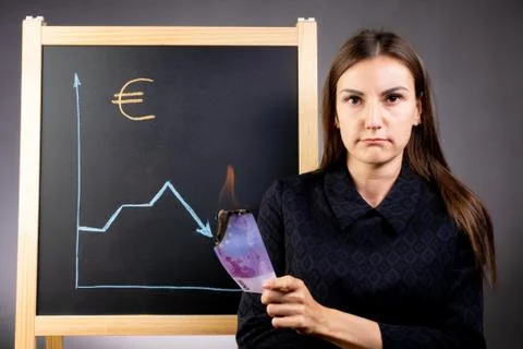 The graph of the fall of the euro is drawn on a black chalkboard, a sad woman is Stock Photos