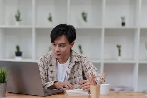 Graphic designer drawing in notebook and using laptop at home. Creative concept Stock Photos