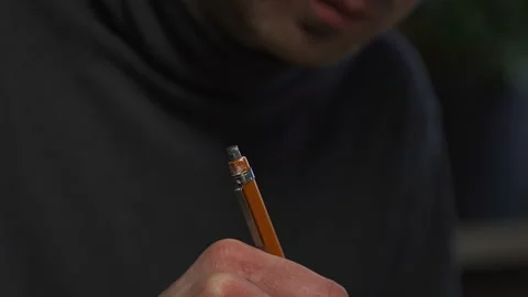 A graphic designer draws a prototype of an icon visual with a pencil on paper Stock Footage 172527282
