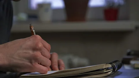 A graphic designer draws a prototype of an icon visual with a pencil on paper Stock Footage 172527315