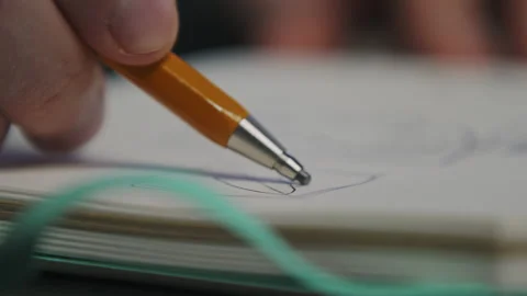 A graphic designer draws a prototype of an icon visual with a pencil on paper Stock Footage 172527489