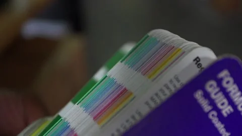 Graphic Designer Flipping through Pantone Color book Slow-Motion Stock Footage 158766052