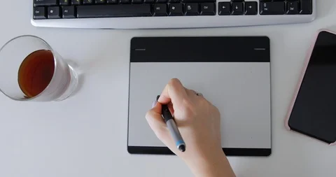 Graphic designer at her work desk drawing on digital tablet and her computer Video stock 127388172