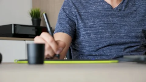 Graphic designer listens to music while drawing on digital tablet Stock Footage 93348693