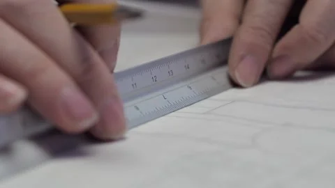 A graphic designer making a line with a ruler over a blueprint on the Stock-Footage 149497731