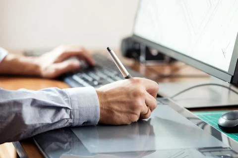 Graphic designer using digital tablet and computer in office or Foto stock