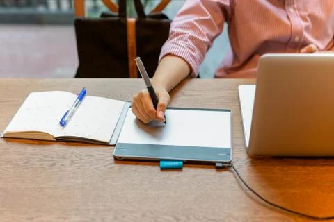 Graphic designer using digital tablet with laptop on the desk. Stock Photos