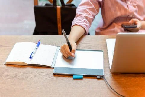 Graphic designer using digital tablet with laptop on the desk. Stock Photos