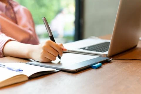 Graphic designer using digital tablet with laptop on the desk. 스톡 사진
