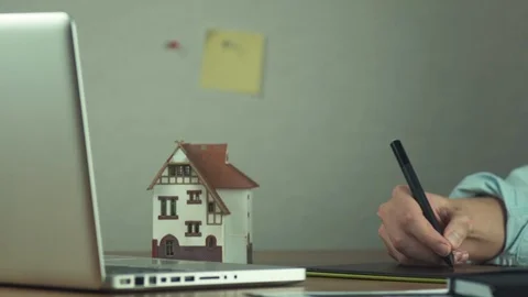 Graphic designer using graphic tablet creating housing project on laptop Stock Footage 81880398