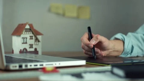 Graphic designer using graphic tablet creating housing project on laptop Stock Footage 81880713