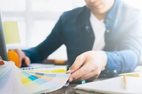 Graphic designer at work with color samples for selection. . Stock Photos