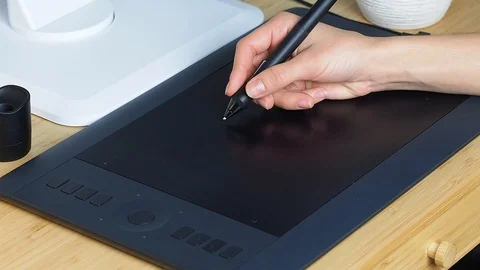Graphic designer at work. The designer draws a graphic pen on the tablet Stock Footage 122021605