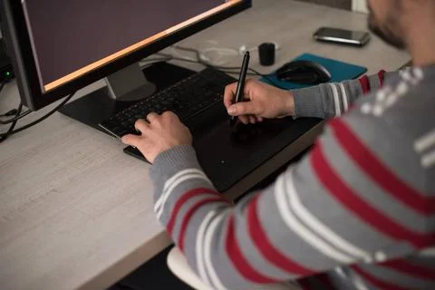 Graphic designer at work Young graphic designer working on a digital table... Stock Photos