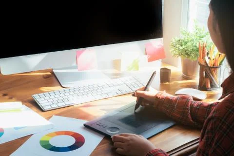 Graphic designer working on computer and used graphics tablet. Stock Photos