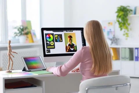 Graphic designer working with computer at table in office, back view Stock Photos