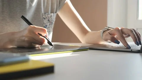 Graphic designer working with digital drawing tablet and pen on a computer Stock Footage 102380203