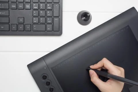 Graphic designer working on digital tablet. The hand draws on a graphics tabl 库存照片