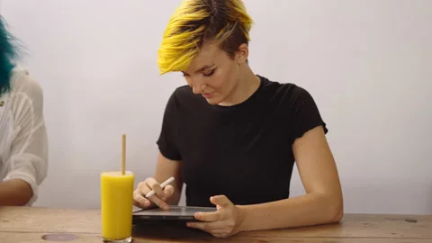 Graphic designer working with tablet and smartpen. Woman sits at wooden table Stock Footage 210807851